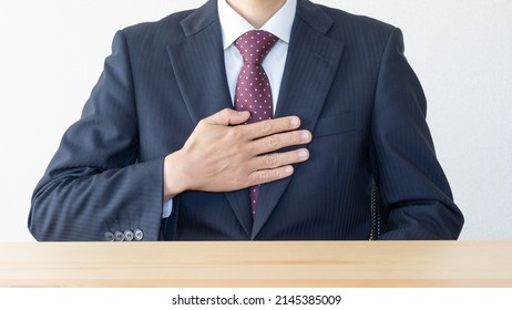 A Businessman Who Puts His Hand On His Chest.