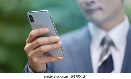 
A businessman who uses a smartphone outdoors