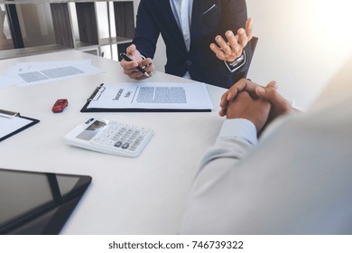 Businessman will be signing a car insurance policy, Agent man is holding the document and waiting for his reply to finish.