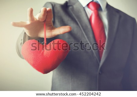 Businessman winning and controling customer's heart concept in Vintage tone
