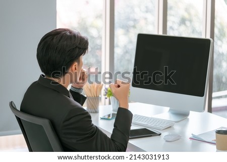 Businessman with winning gesture infront of a Blank computer screen for mock up and template of Business succes concept.