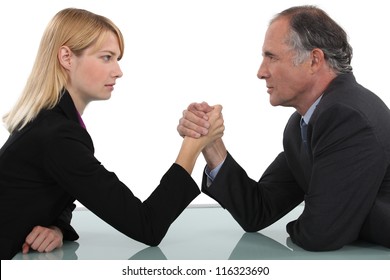 Businessman and woman arm wrestling