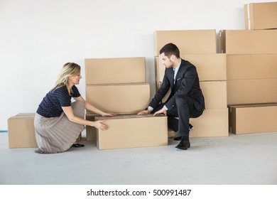 Businessman And -woman Lifting Cardboard Box