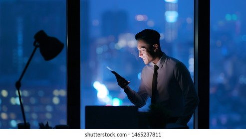 businessman work excitedly and read the message by smartphone at night