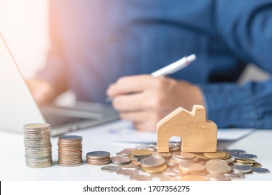 A businessman work form home and self quarantine while Coronavirus, Covid-19 pandemic situation. Concept of Property investment and house mortgage financial. A young man planning for refinance dept. - Shutterstock ID 1707356275