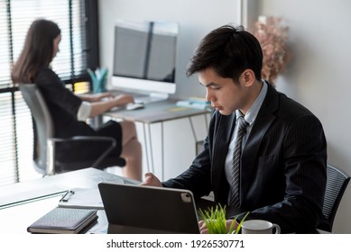 ิAsian Businessman Work In The Office Using Tablet And Mobile Phone.