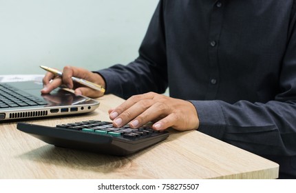 Businessman Working With Business Documents On Wooden Office Table With Computer Notebook And Calculator