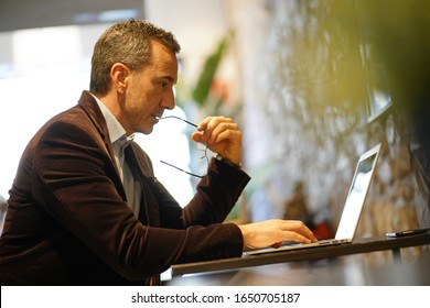 Businessman Working In Coffee Shop On Laptop Computer