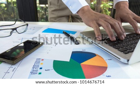 Businessman working at ffice workplace with laptop and business chart documents