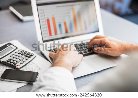 Businessman working in his laptop in a modern office.