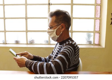 Businessman Working At Home Office In Time Of COVID-19 Pandemic With Cell Phone And Protection Mask, Form Original Design Of Work At Home With Glass Window Background