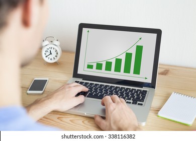 Businessman working at home on laptop and smartphone on sustainable development project - Powered by Shutterstock