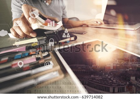 businessman working with laptop computer and document on wooden desk in modern office with virtual icons interface