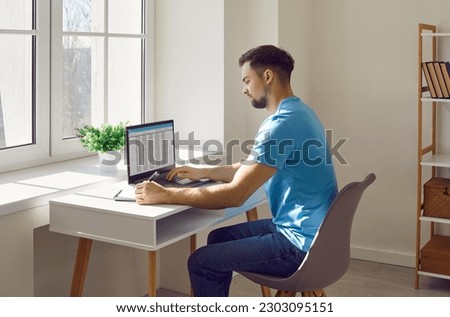 Businessman working with laptop and documents on his desk in office. Male accountant, analyst, financial manager sitting at desk in front of window planning, accounting report spreadsheet