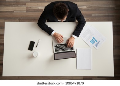 Businessman Working With Laptop And Documents Sitting At Office Desk, Employee Or Company Ceo Using Online Apps Software At Workplace, Man In Suit Typing On Computer, Top Overhead View From Above