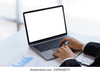 Businessman working with a laptop with an empty screen for your advertisement in an office environment - Powered by Shutterstock