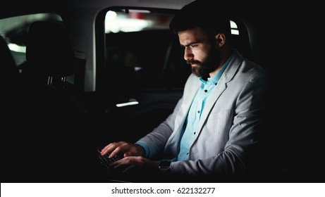 Businessman Working Late At Car Finishing His Job. Hard Work Overtime Driving Home.