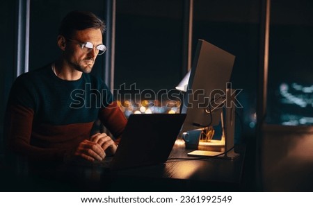 Businessman working late in his home office, engaging in a virtual meeting with his team. Professional man using a laptop to communicate and plan a project ahead of the deadline.