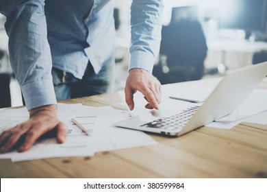 Businessman working in modern cretive studio. Using generic design laptop. Architectural project on table. Blurred background, horizontal mockup. - Powered by Shutterstock