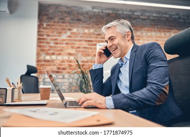 Businessman working in office with computer and talking on phone in the loft office