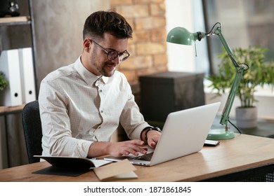 Businessman working in the office on his laptop. Stylish businessman working on a project in the office. - Shutterstock ID 1871861845
