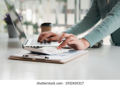 businessman working on desk office with using a calculator to calculate the numbers, finance accounting concept