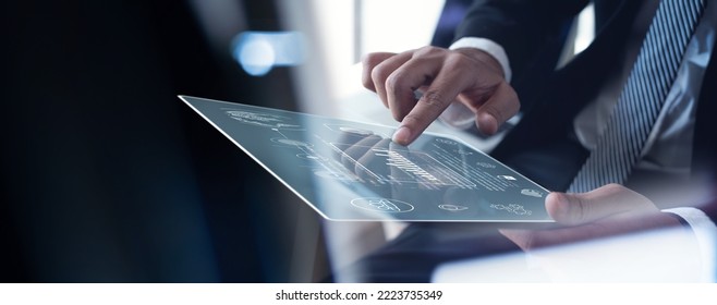 Businessman working on digital tablet analyzing business document with financial graph, market report, business data analysis, digital marketing, project planning, strategy and solution