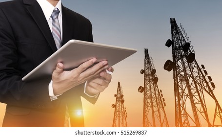 Businessman Working On Digital Tablet, With Satellite Dish Telecom Network On Telecommunication Tower In Sunset, Telecommunication In Business And Development