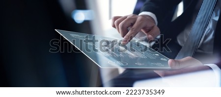 Businessman working on digital tablet analyzing business document with financial graph, market report, business data analysis, digital marketing, project planning, strategy and solution