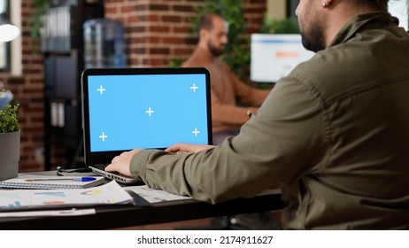 Businessman working on freelance with greenscreen on laptop in company office. Looking at pc display with blank chroma key template and isolated copyspace mockup on background. - Shutterstock ID 2174911627