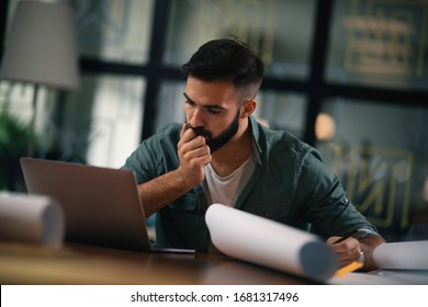 Businessman working on his laptop.
Handsome young man working in office.