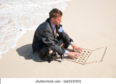 Businessman working on his sand laptop next to foamy white waves washing up the beach - Shutterstock ID 1663131931