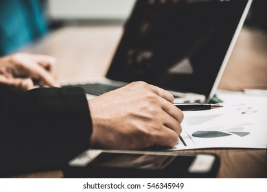Businessman working on his wooden table in the office with calculator,document,smart phone,pen and laptop in business,finance and banking concept - Shutterstock ID 546345949