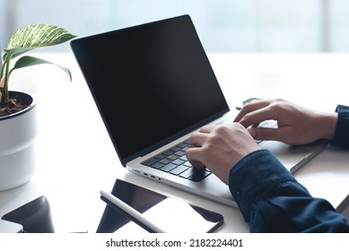 Businessman working on laptop computer at home office. Casual business man, freelancer using portable computer devices, surfing the internet networking on table at workplace
