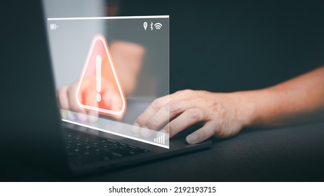 Businessman working on laptop computer, exclamation mark, alarm, warning, computer virus detected, danger warning concept or information error that should be urgently fixed and repaired. - Shutterstock ID 2192193715