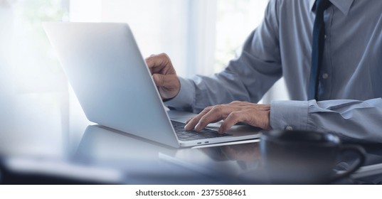 Businessman working on laptop computer at modern office, business man hands typing on laptop keyboard, surfing the internet, online working, close up. corporate business concept - Powered by Shutterstock