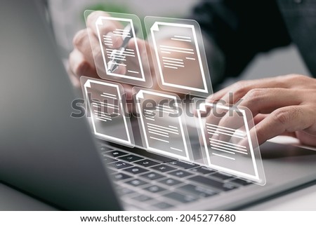 Businessman working on laptop computer with electronics document icons, E-document management, online documentation database, paperless office concept