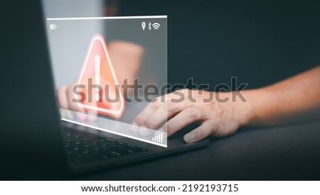Businessman working on laptop computer, exclamation mark, alarm, warning, computer virus detected, danger warning concept or information error that should be urgently fixed and repaired.