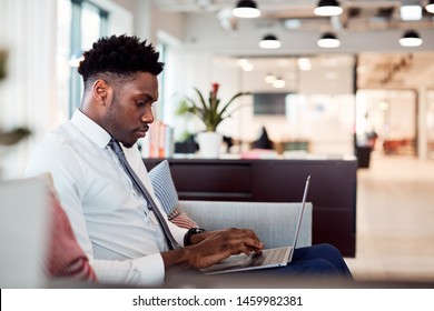 Businessman Working On Laptop At Desk In Shared Workspace Office