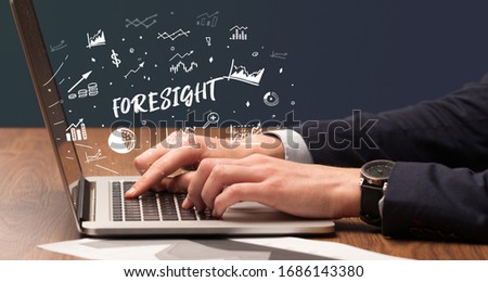 Businessman working on laptop with FORESIGHT inscription, modern business concept