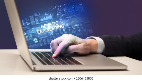 Businessman working on laptop with GENETIC ENGINEERING inscription, cyber technology concept - Shutterstock ID 1606455838