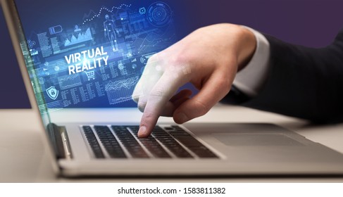 Businessman working on laptop with VIRTUAL REALITY inscription, cyber technology concept - Shutterstock ID 1583811382