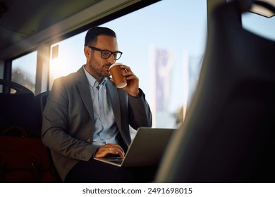 Businessman working on laptop while commuting by public transport. - Powered by Shutterstock