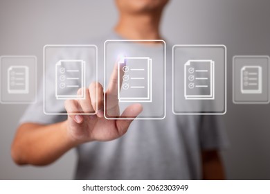Businessman working on modern computer on virtual screen, paperwork with checkbox lists, compliance rules and law regulatory policy concept. - Shutterstock ID 2062303949