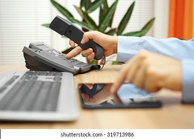 businessman working on tablet computer  is calling service for support