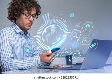 Businessman working with phone in hand, laptop on office desk. Earth sphere with worldwide connection hologram, icons hud menu. Concept of digital marketing