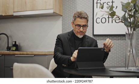 Businessman working with tablet computer in home office. Serious middle aged, mid adult, mature age man. Entrepreneur sitting at desk, managing business online. - Powered by Shutterstock