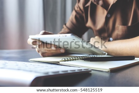 businessman working tablet in office with film colors tone, soft-focus and over light in the background