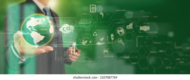 Businessman working virtual globe modern computer to reduce CO2 emissions carbon footprint climate change to limit global warming.Sustainable development and innovation green business concept. - Shutterstock ID 2107087769