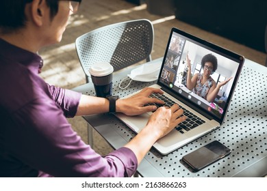 Businessman working while having online meeting with multiracial coworkers through laptop in office. unaltered, wireless technology, video conference, discussion, internet, business, teamwork, covid. - Shutterstock ID 2163866263